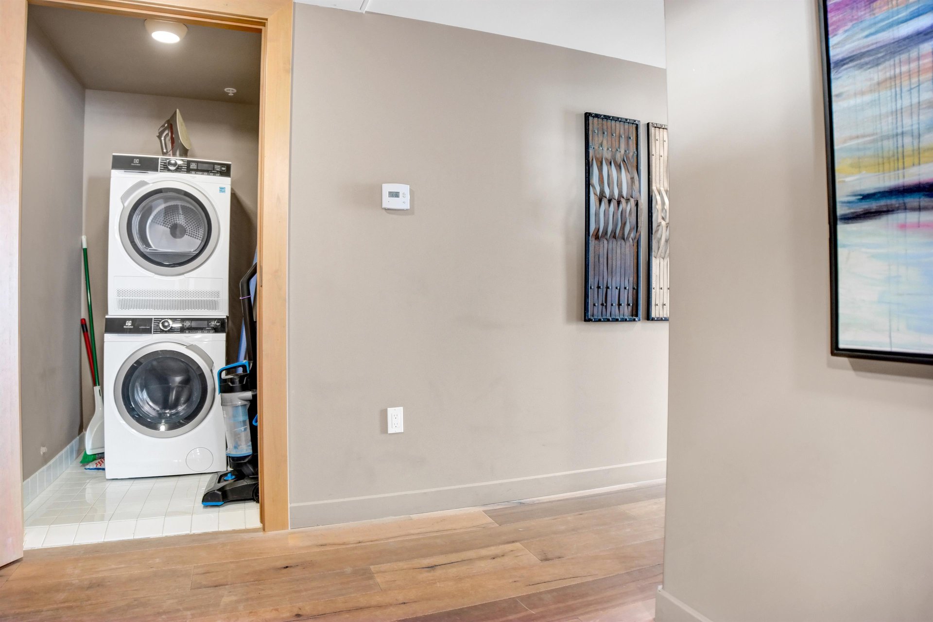 Inunit laundry area with stacked washer and dryer conveniently located off the hallway.