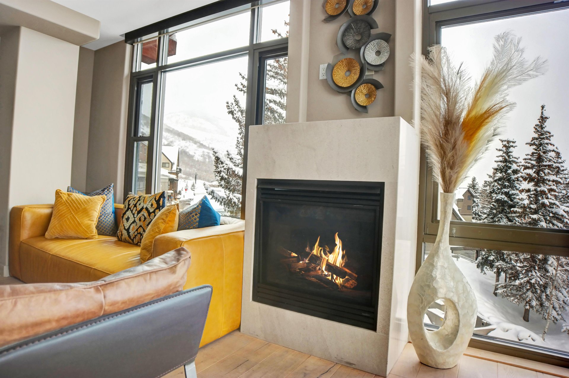 ozy gas fireplace with mountaininspired decor and large windows overlooking the snowy scenery.