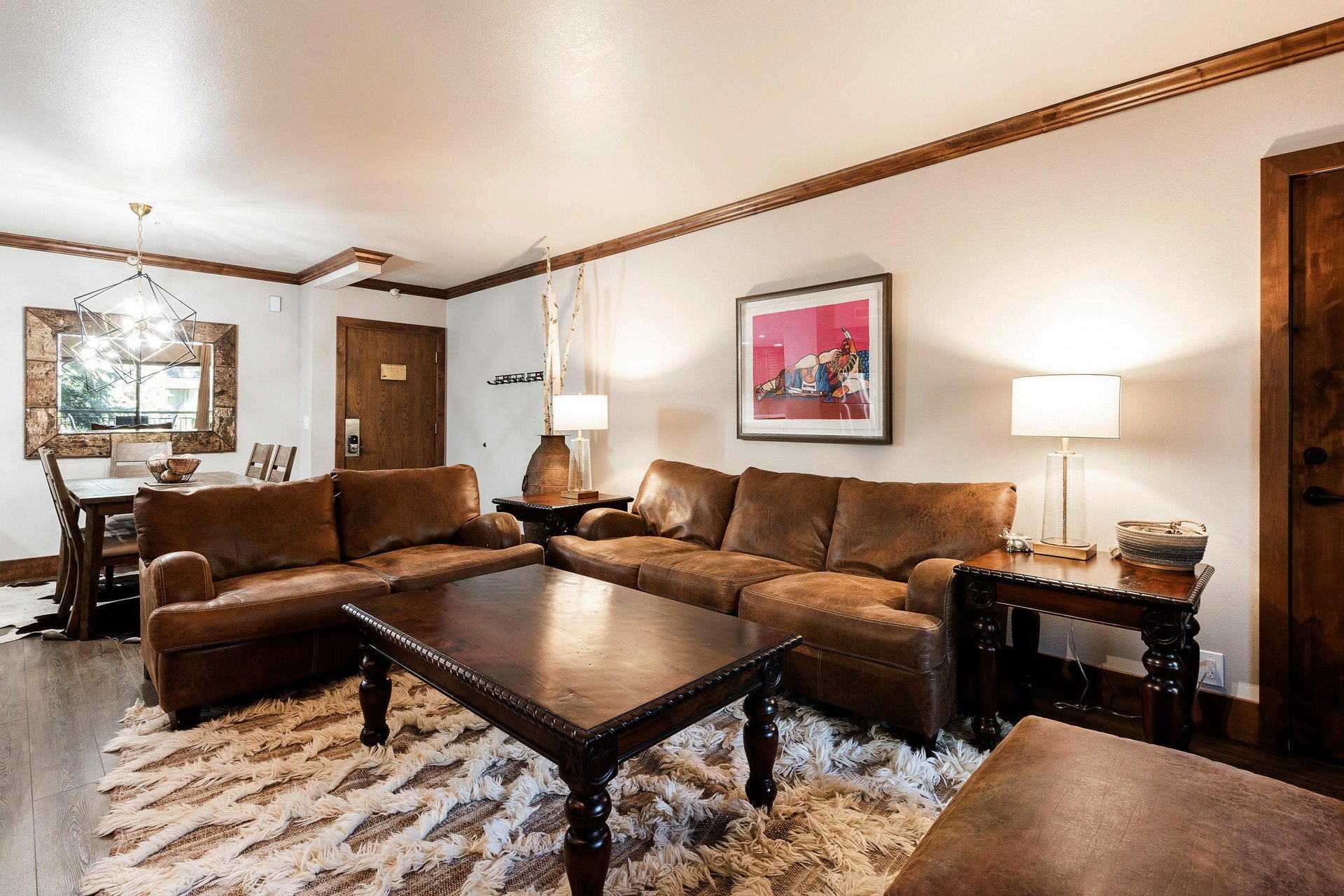 Comfortable living room with leather sectional, warm lighting and rustic mountaininspired accents.