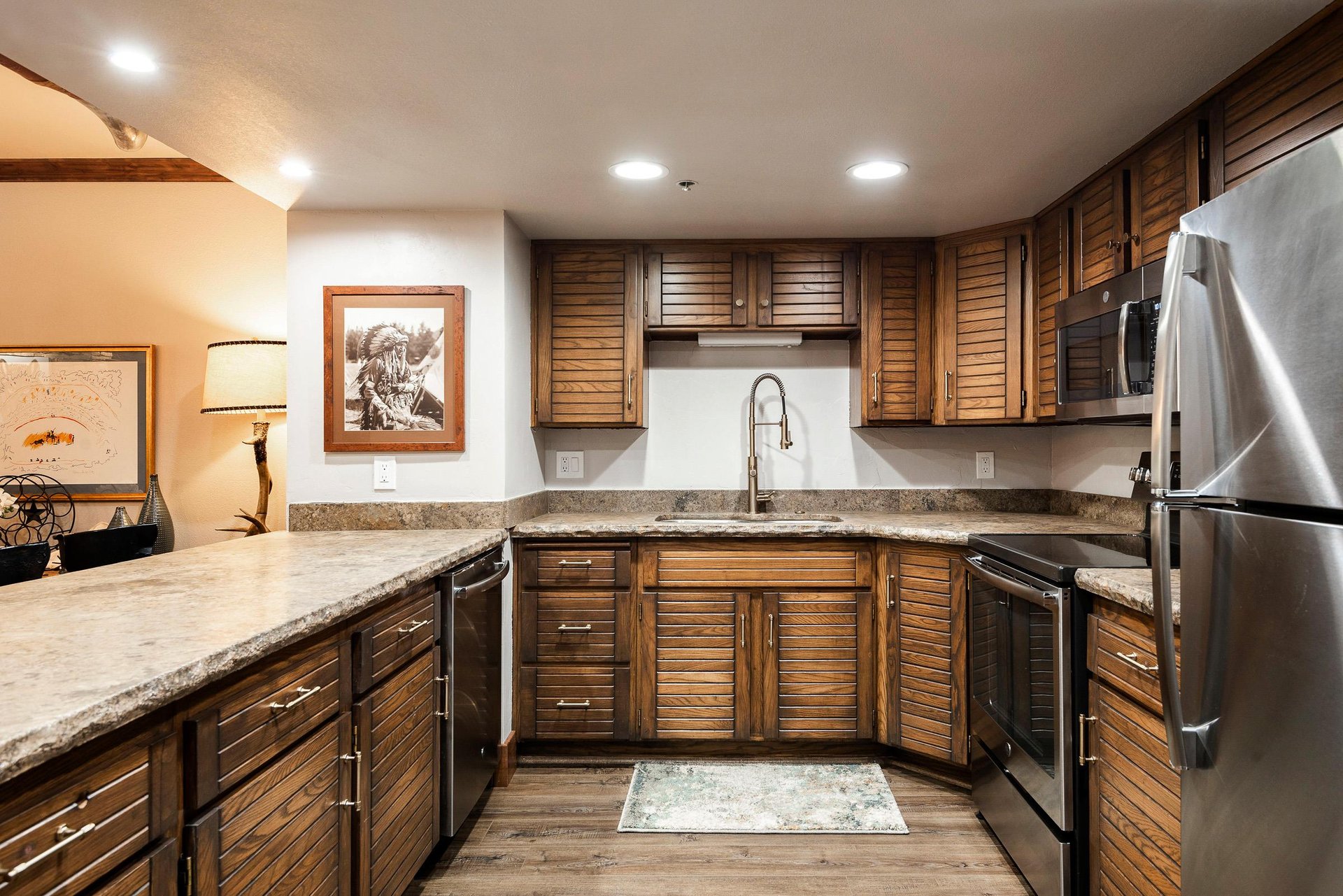 Fully equipped kitchen with wood cabinetry, granite countertops, tile backsplash and stainless steel appliances.