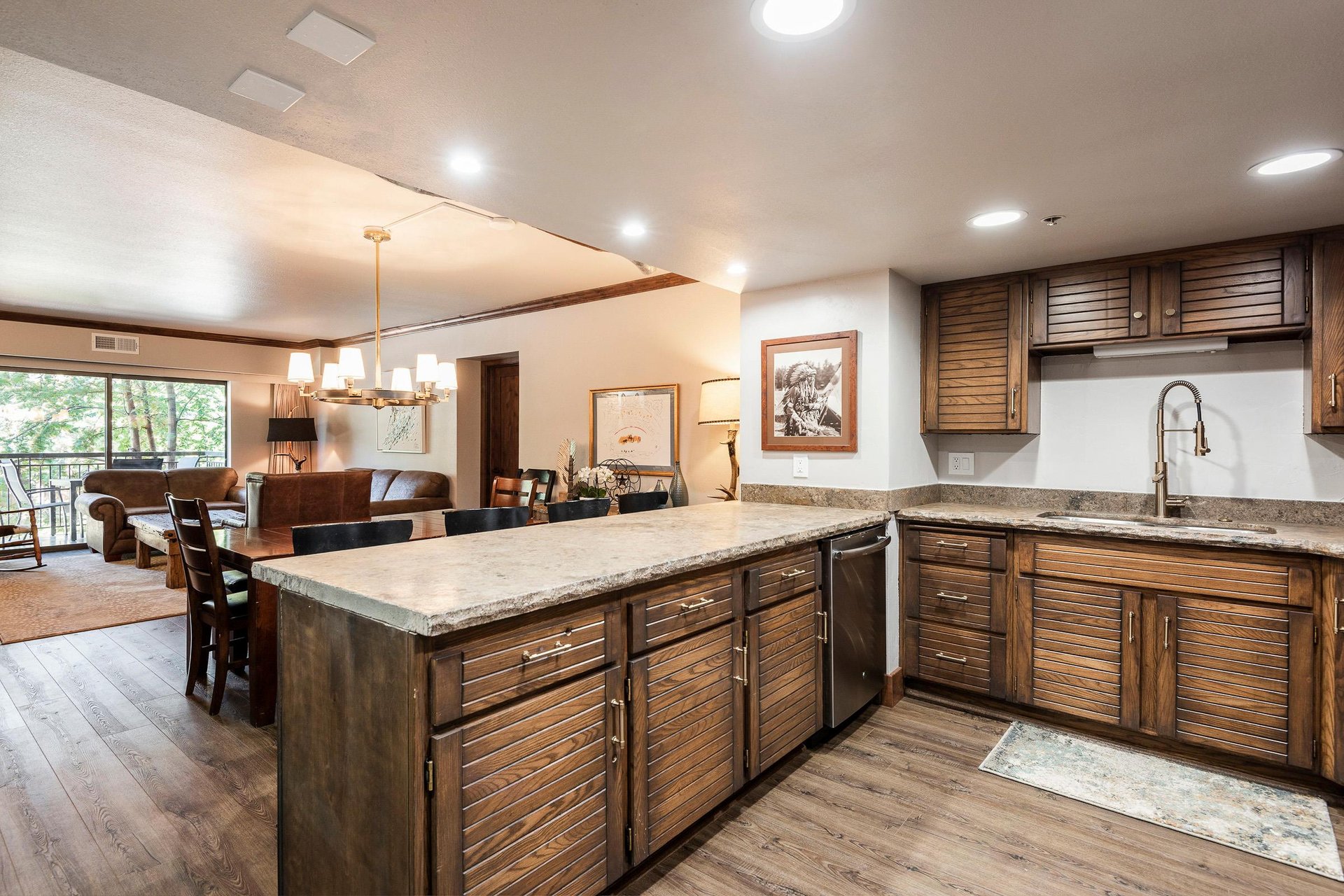 Spacious kitchen with granite peninsula, wood cabinetry and open layout connecting to the dining area.