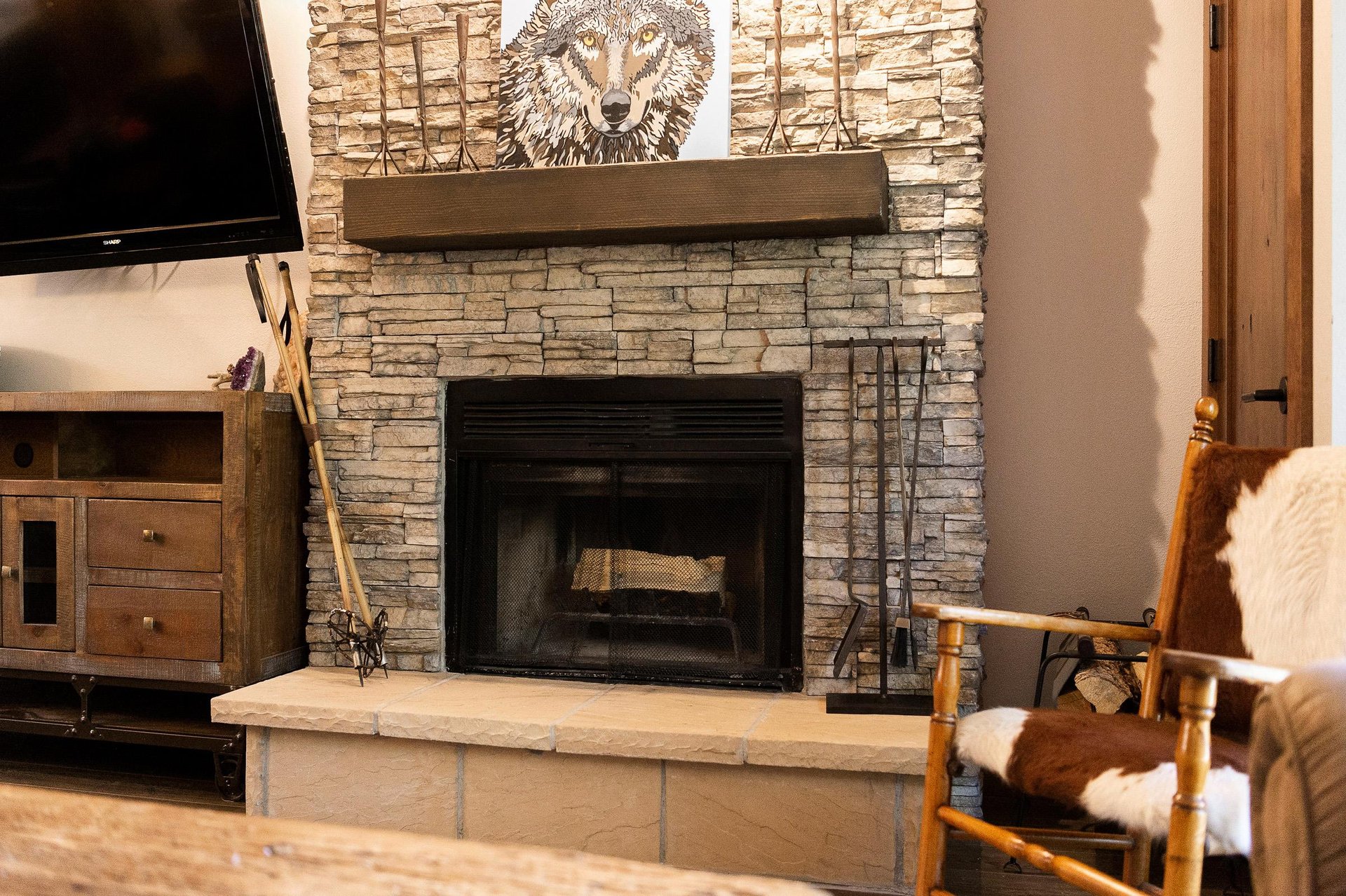 Rustic stone fireplace with raised hearth and wood mantel in the living room.
