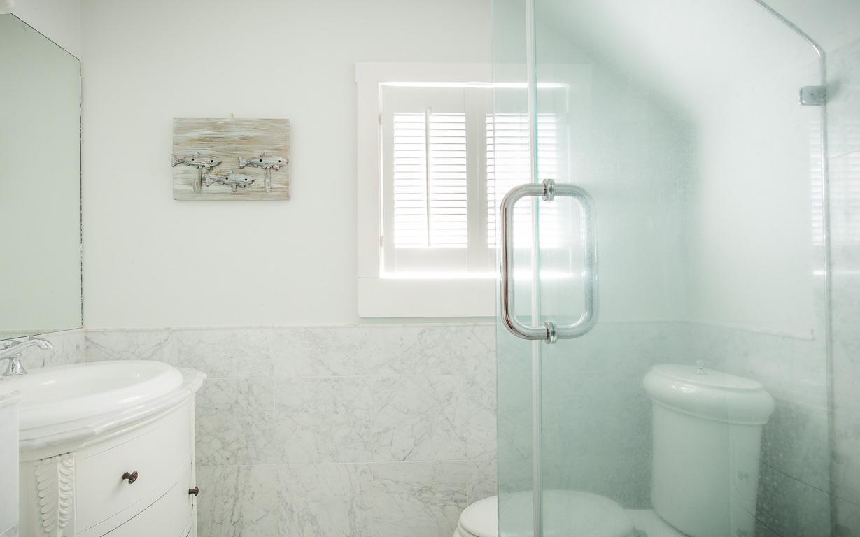The third floor guest bathroom features Carrera Marble tile.