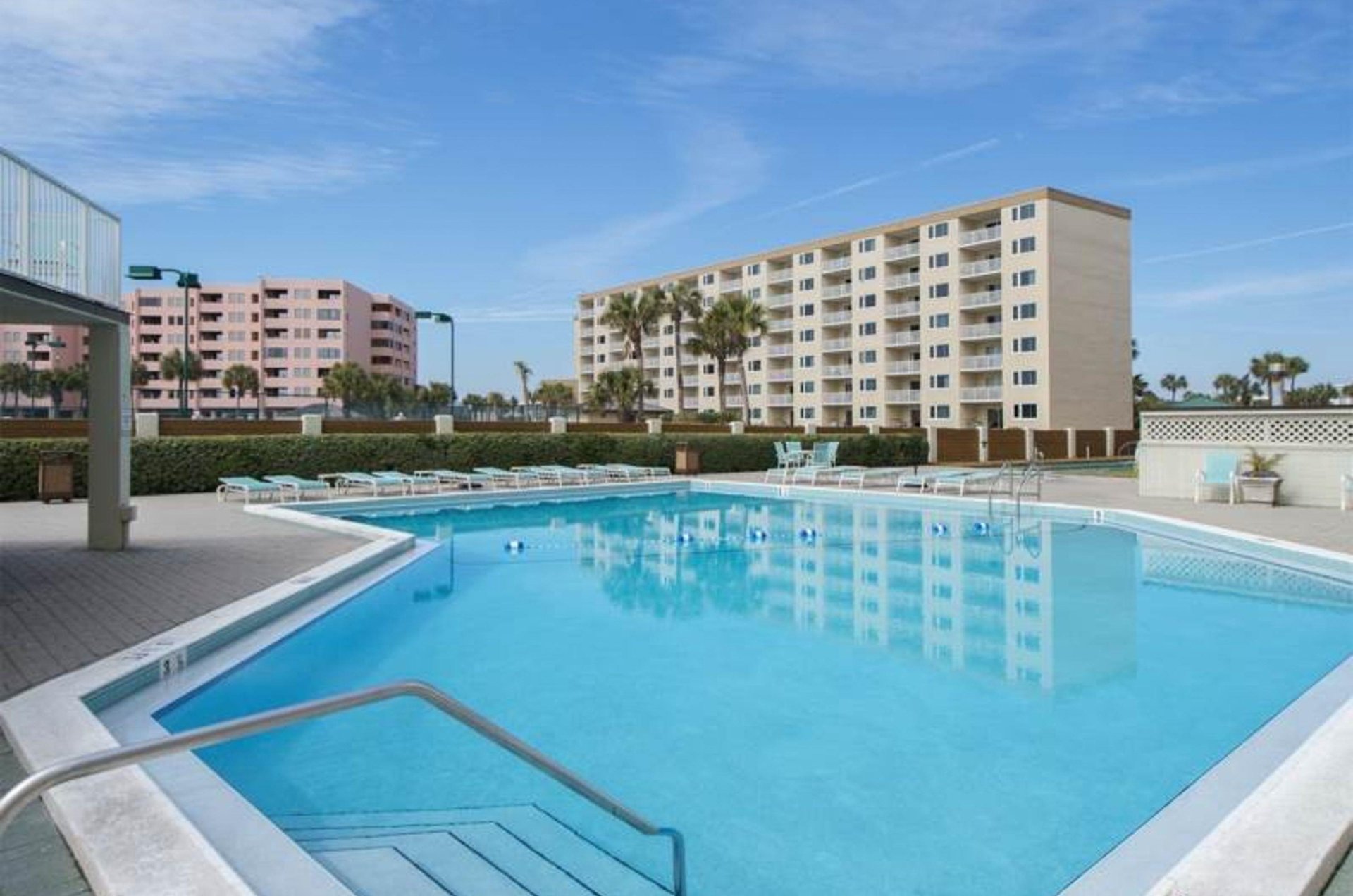 The community swimming pool and sundeck equipped with lots of loungers.