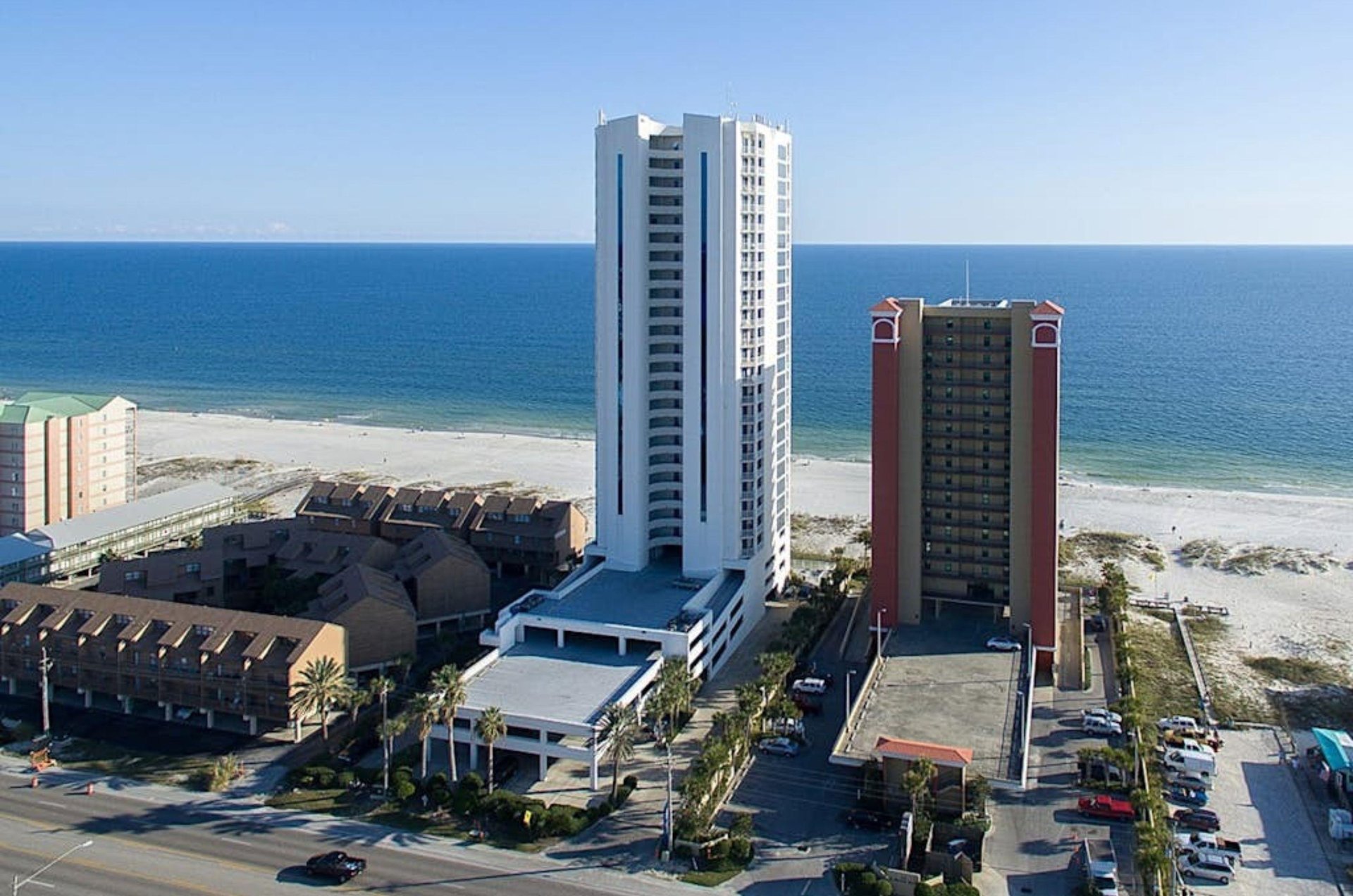 Birds eye view from the streetside of Island Tower with the Gulf in the background