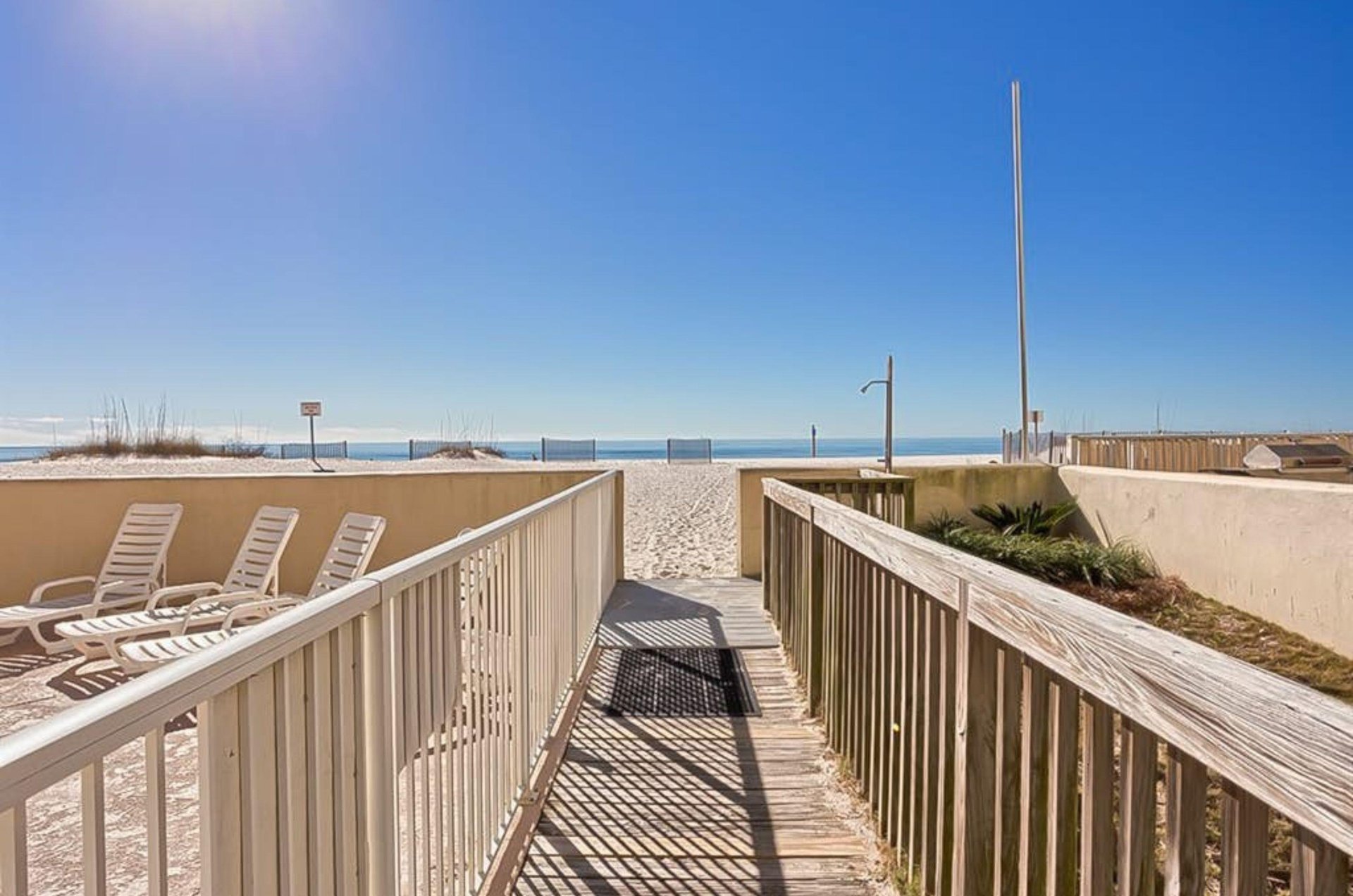 A wooden boardwalk leading to the beach and the Gulf