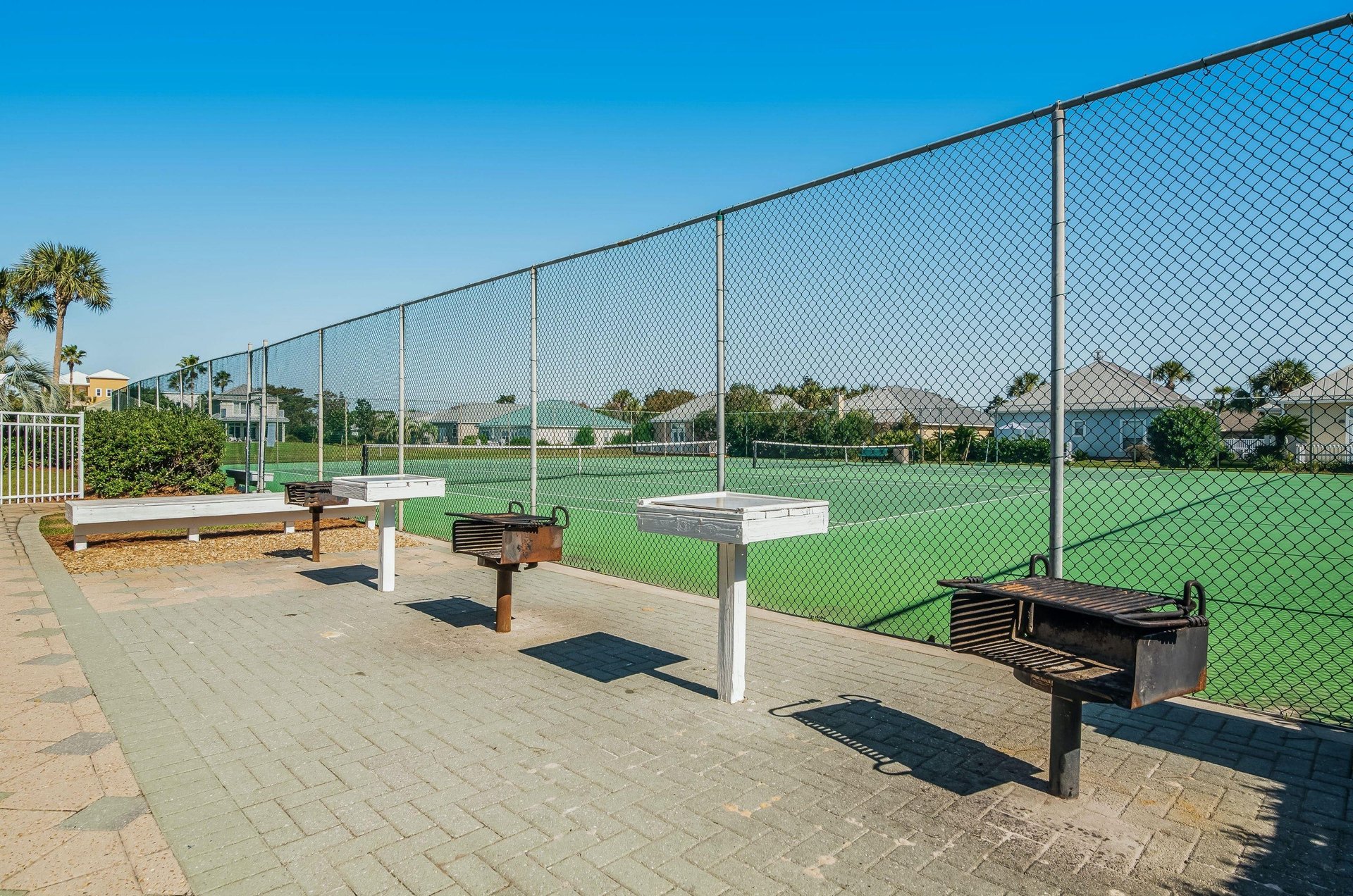 A grilling patio next to the tennis courts