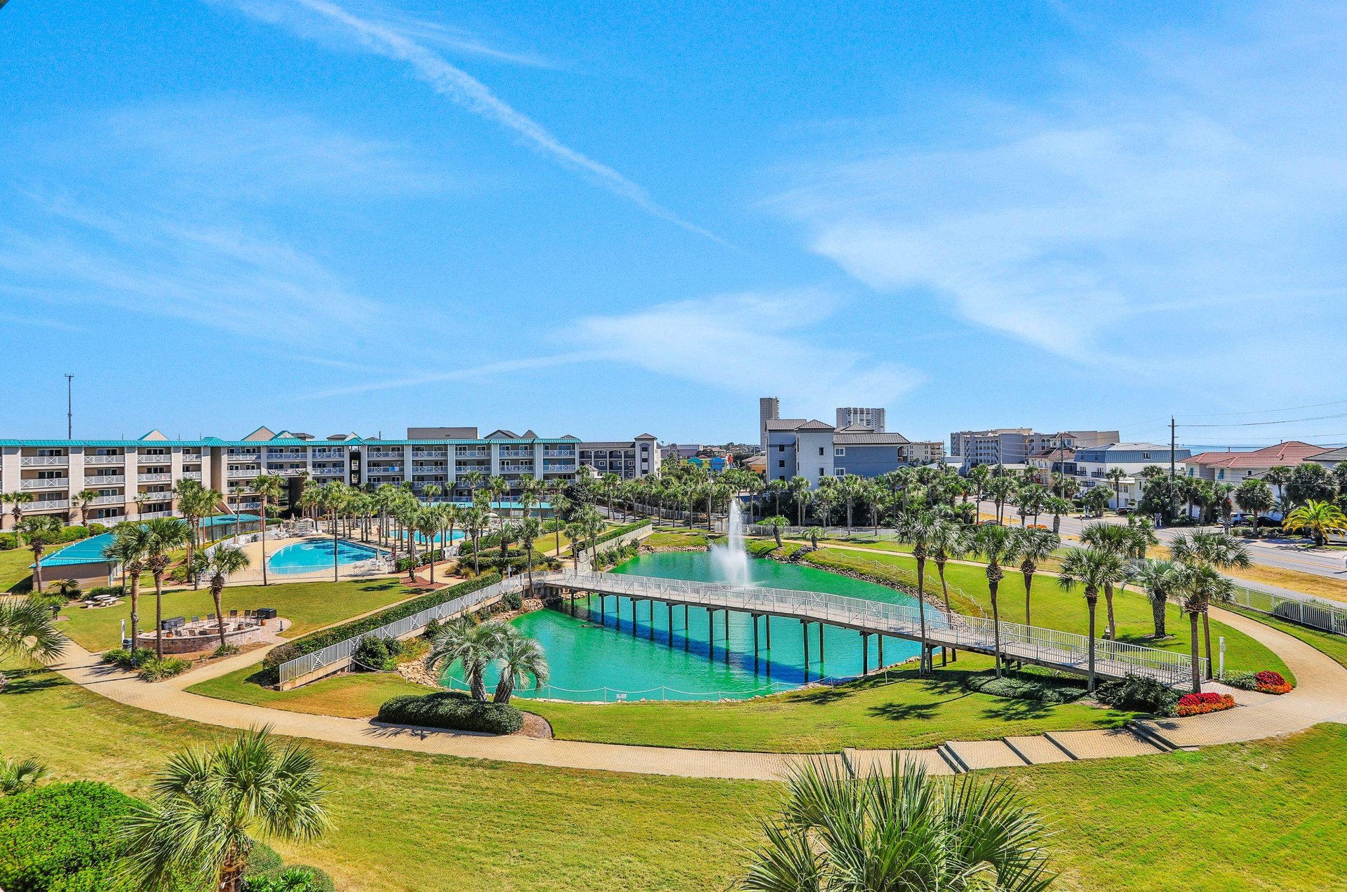 Two sparkling pools, a large pond and towering palms dot the complexs tropical landscape.