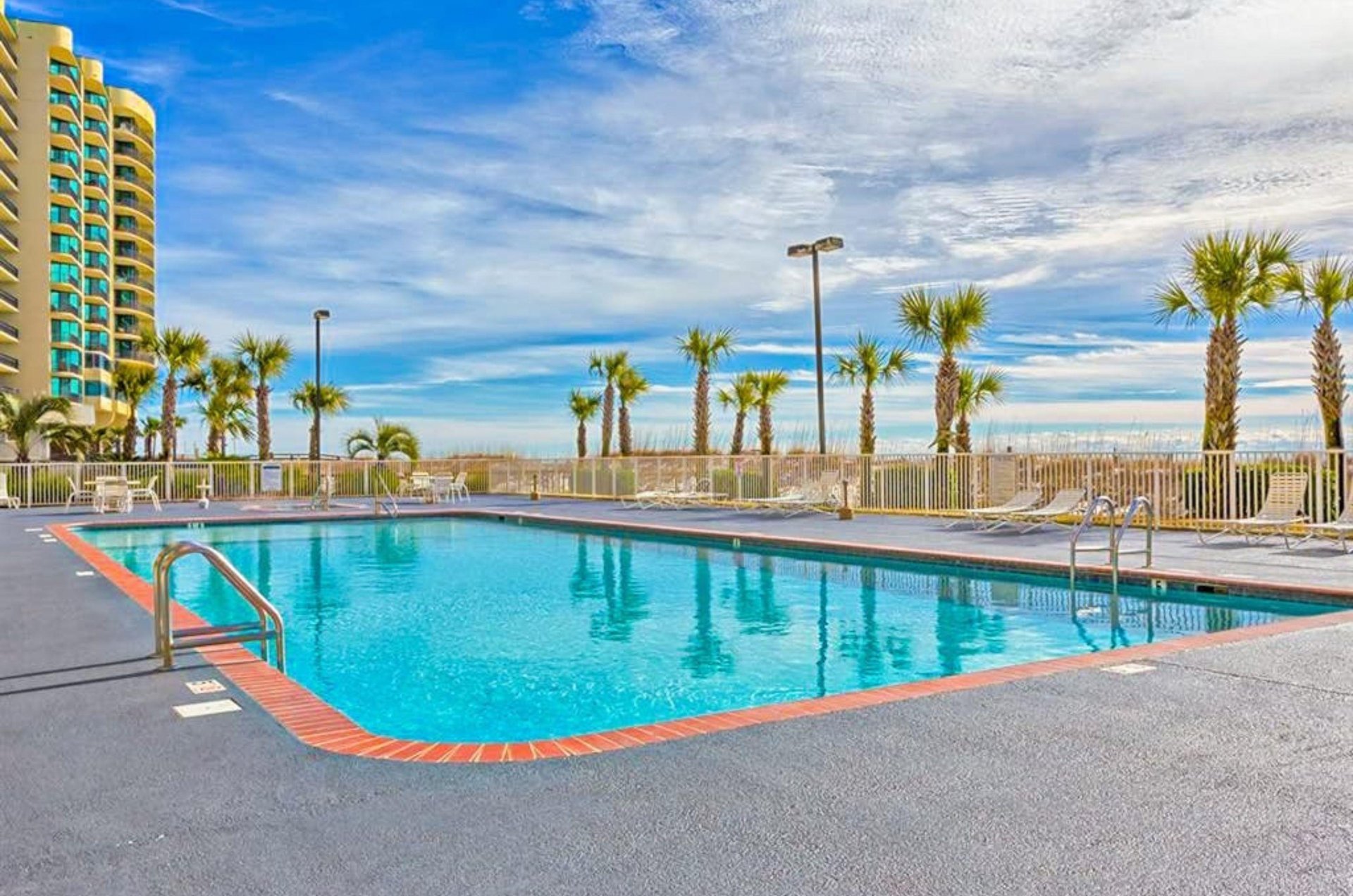 The outdoor swimming pool next to the beach at Regency Isle