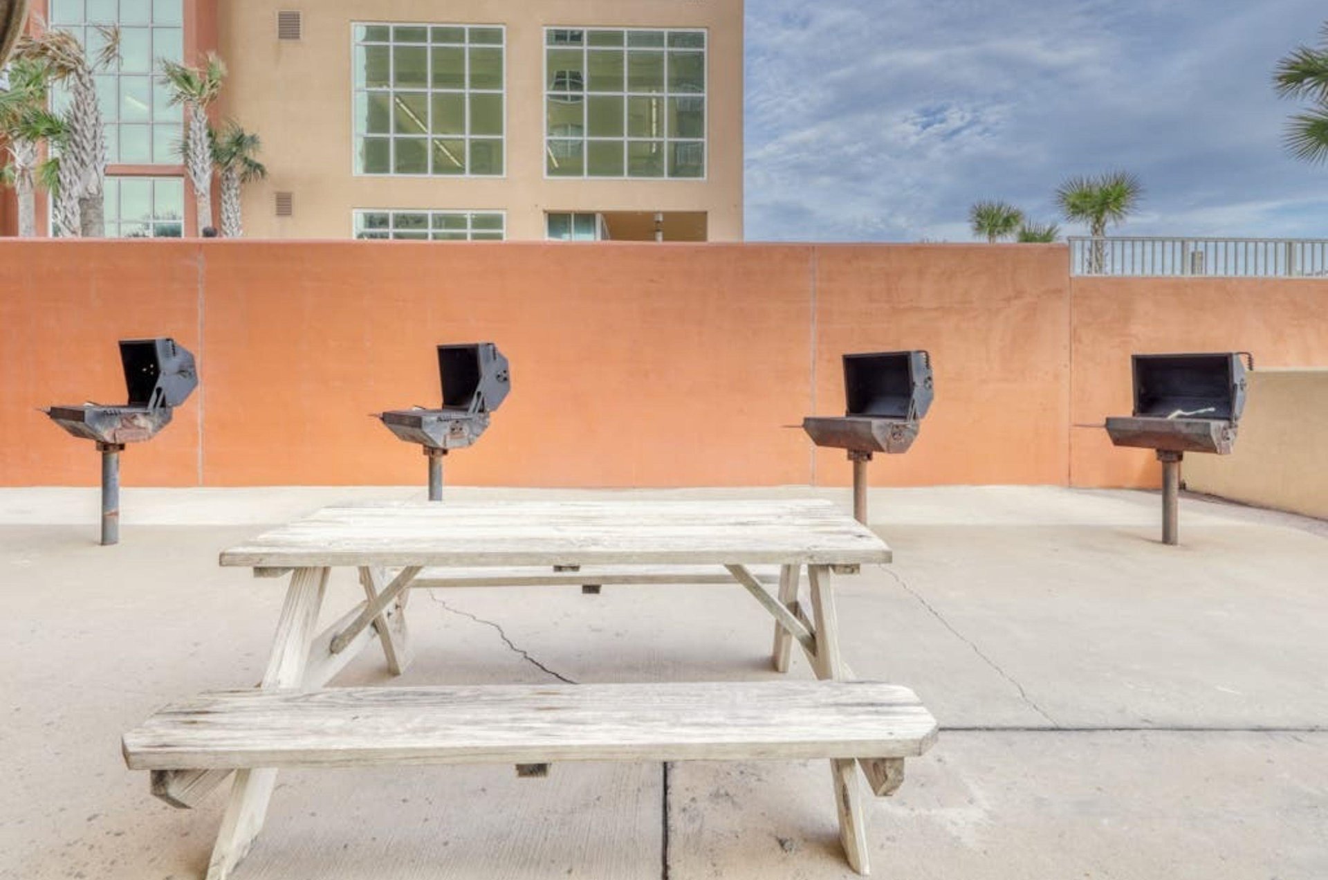 Barbecue grills behind a wooden picnic table at Island Royale in Gulf Shores Alabama