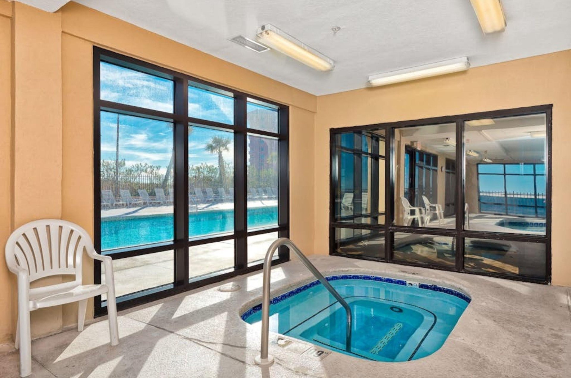 The indoor hot tub overlooking the outdoor pool deck at Grand Pointe in Orange Beach Alabama