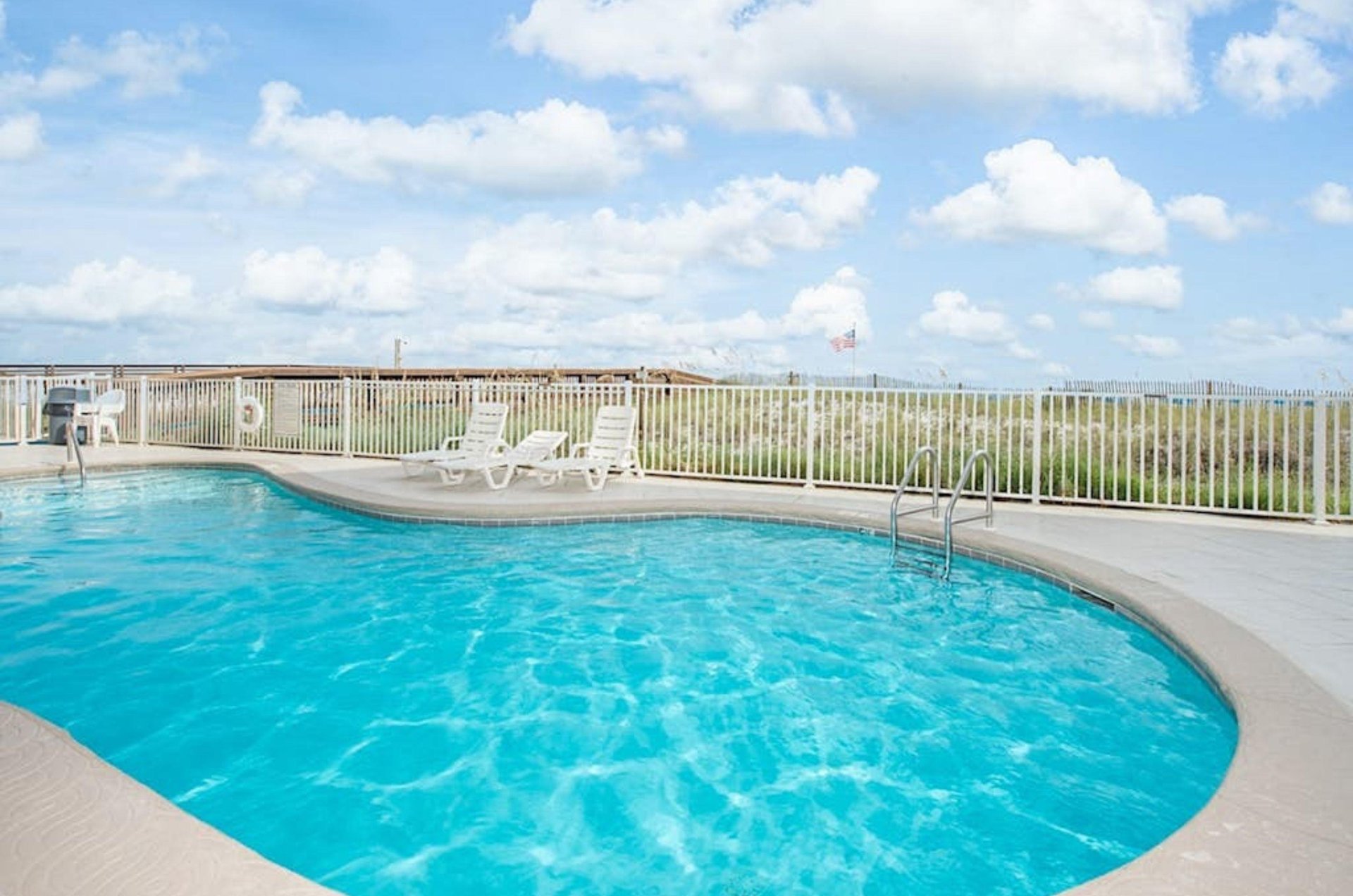 The outdoor swimming pool overlooking the beach at Harbour Place in Orange Beach Alabama