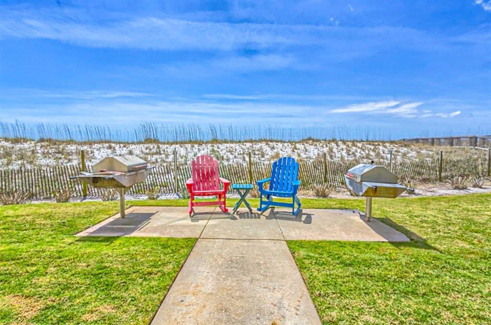 Beachisde barbecue grills next to lounge chairs at Dolphin Key in Orange Beach Alabama