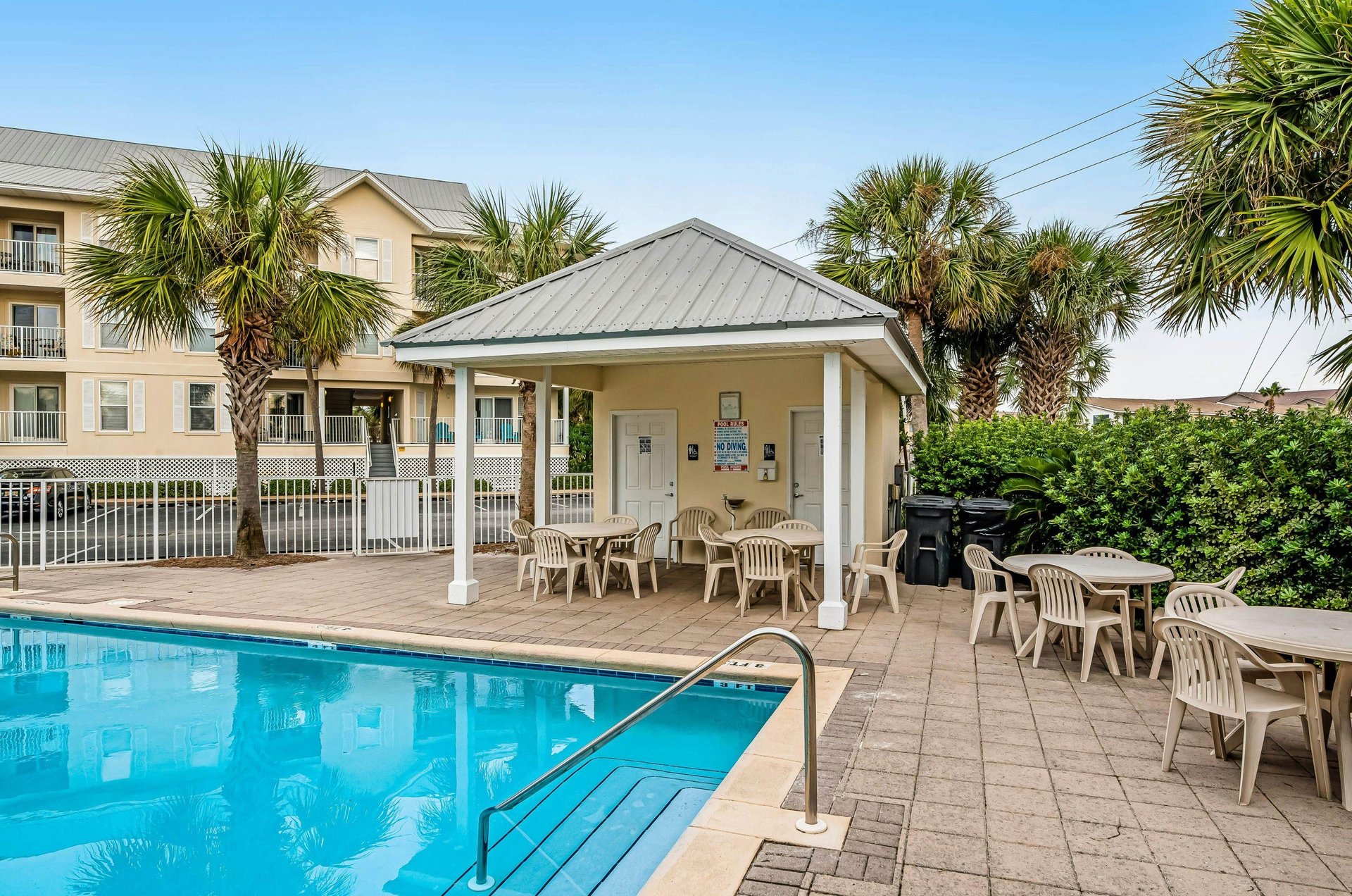 The clubhouse next to poolside chairs and tables at Gulf Island Condos
