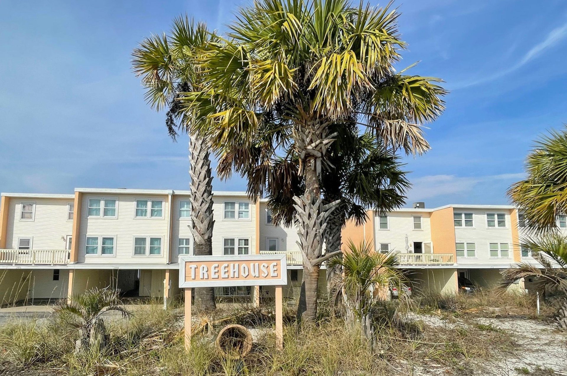 View from the street of the propertys sign and exterior at Treehouse Townhomes