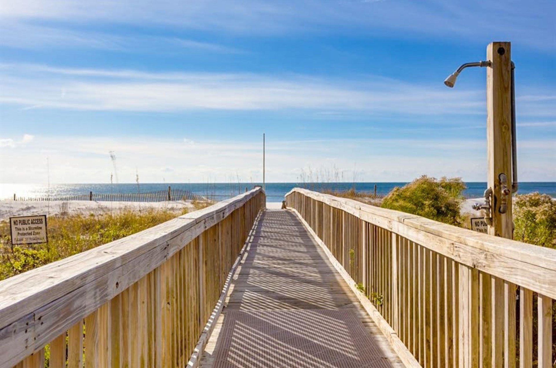 The boardwalk and outdoor shower and Mediterranean Condominiums