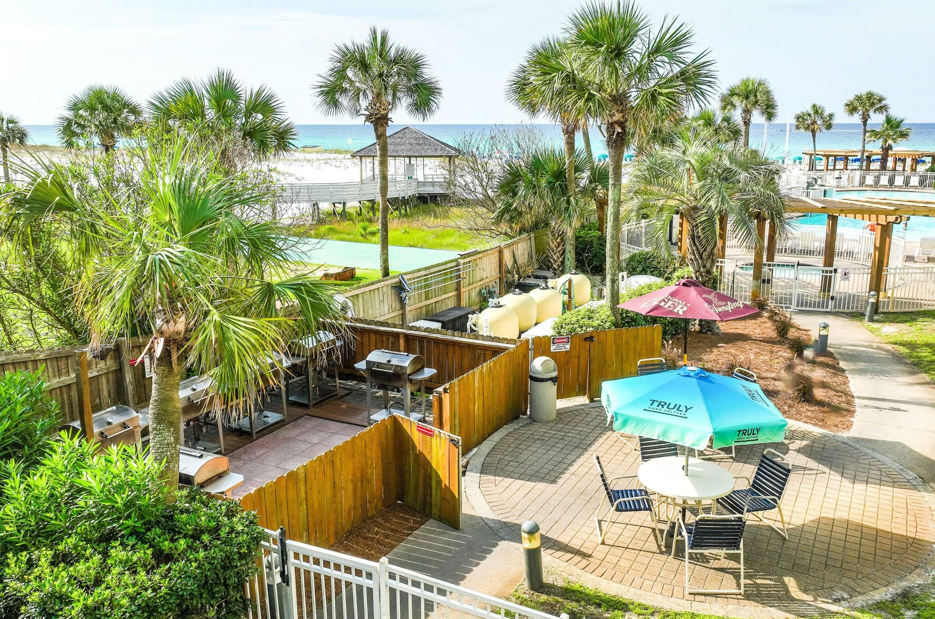 A poolside patio with grills and seating for outdoor cooking and dining