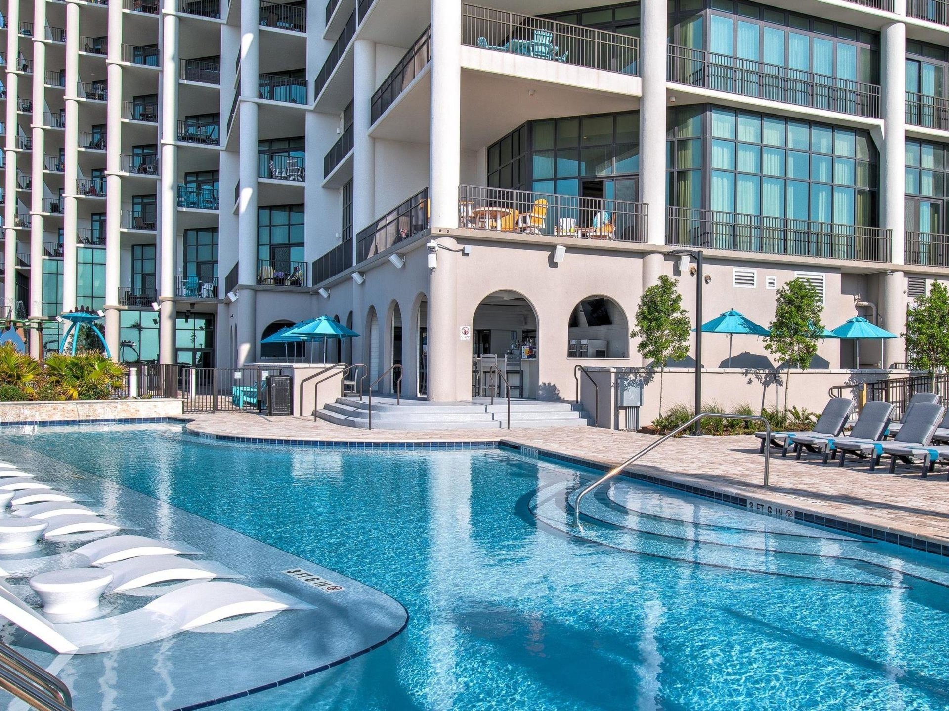 Lounge chairs in the shallow end of the swimming pool at The Oasis at Orange Beach