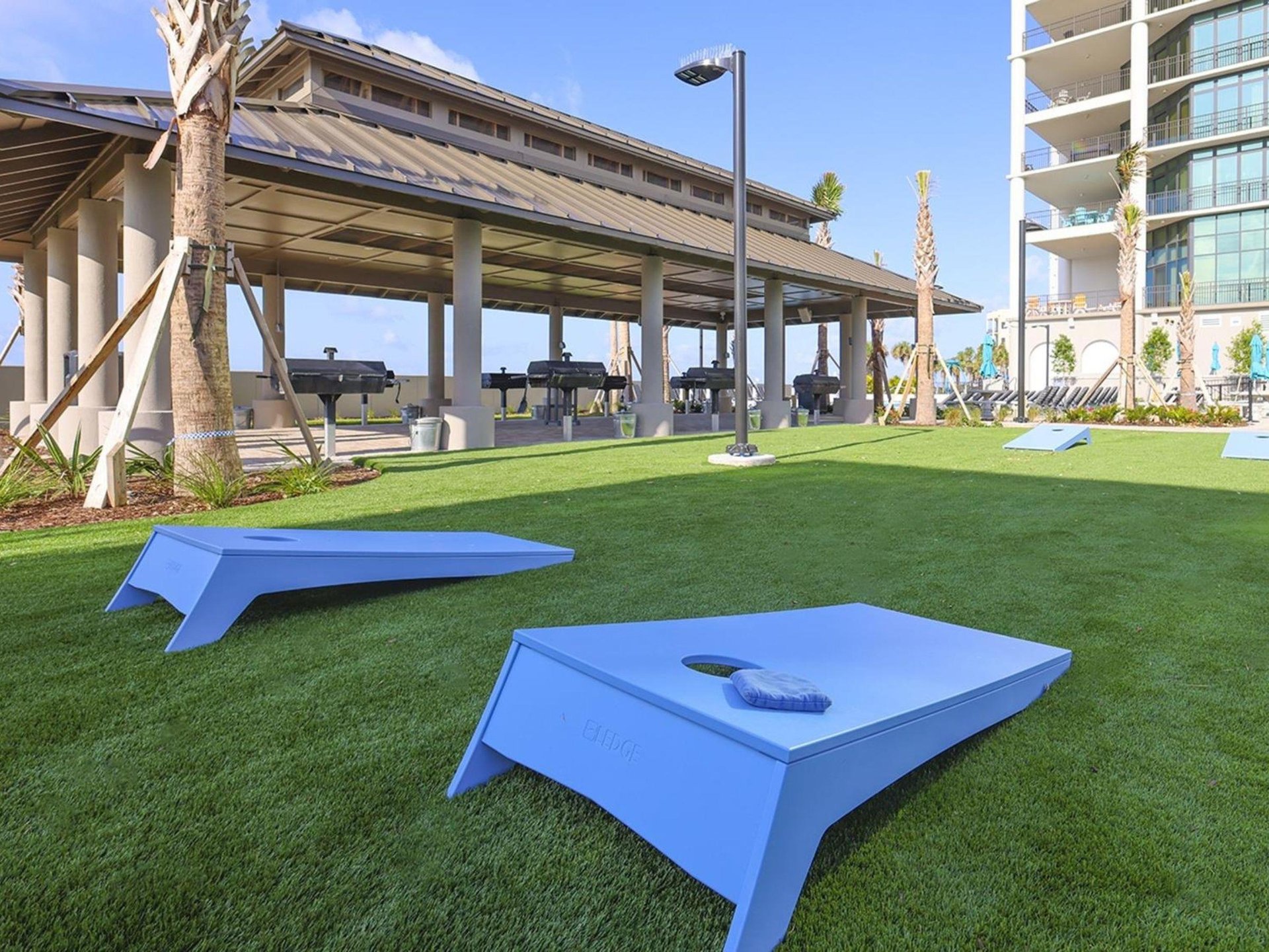 The outdoor patio with grills and cornhole