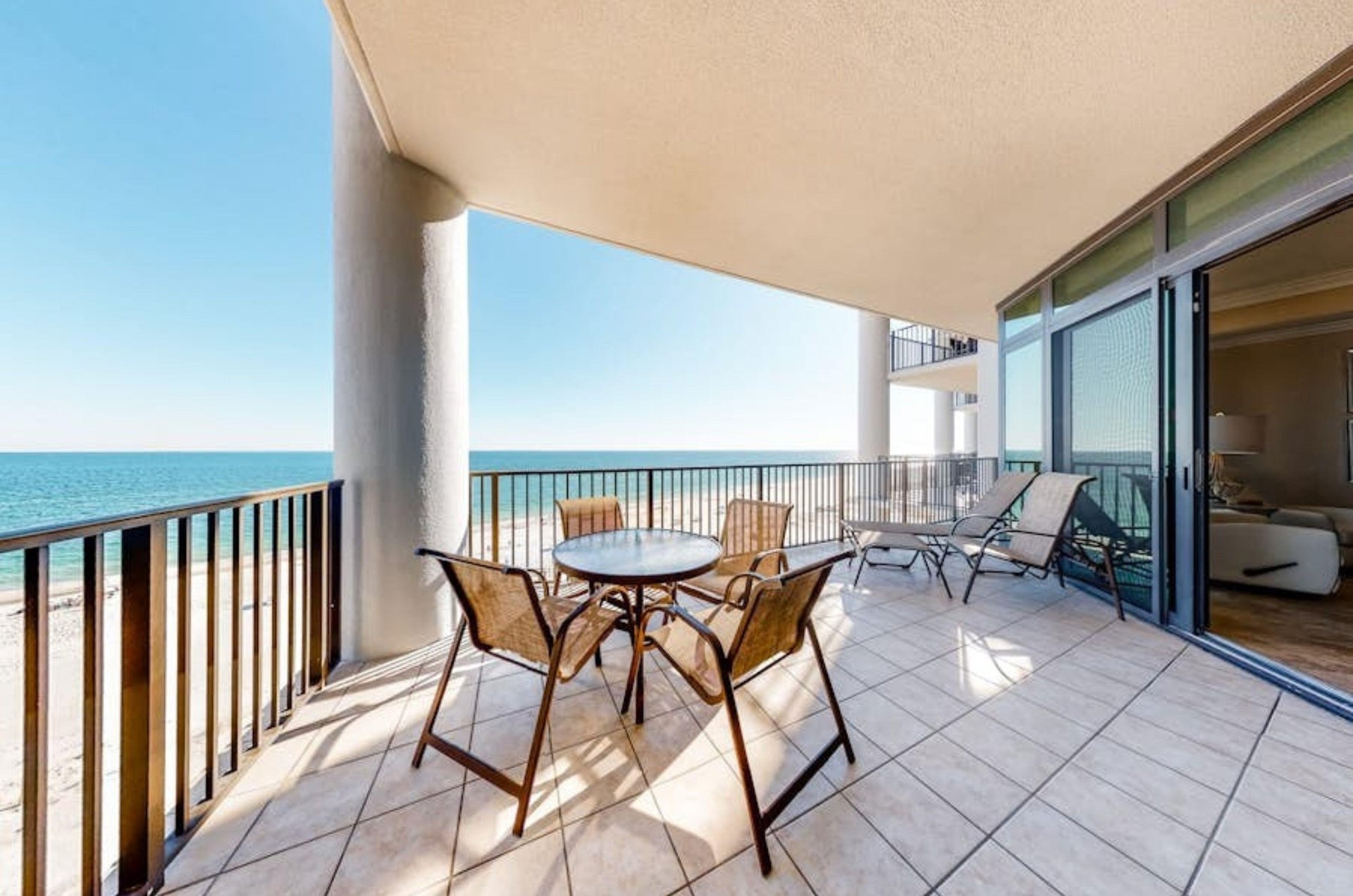 A private balcony with a table and chairs overlooking the Gulf