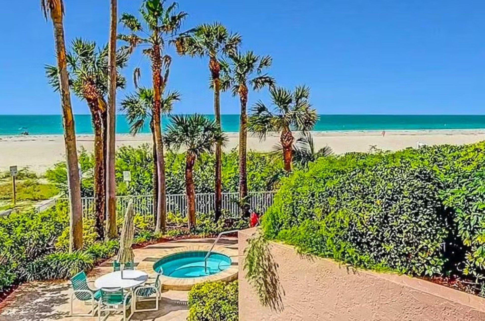 The outdoor hot tub amid tropical landscaping is near the beach.