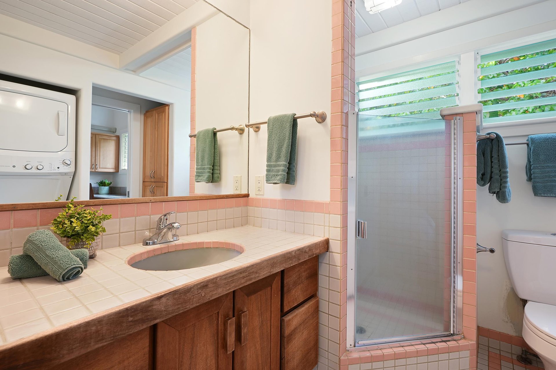 Full size bathroom with stacked washer and dryer