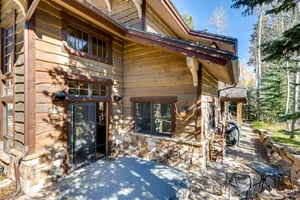 Outdoor living at its best at the Red Pine Residence, complete with a private hot tub, patio table and chairs, and BBQ