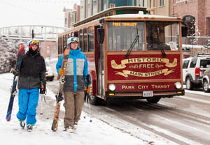 Two skiers catch the Historic Main Street free trolley on a snowy winter day