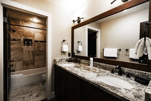 Full bathroom in the den with dual vanity, granite countertops