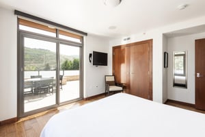 Second bedroom, king bed, wall mounted TV, wooden closet French doors, full length mirror