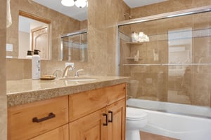 Full bathroom with granite countertops, tiled walls, glass sliding shower door