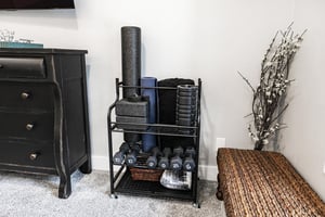 Exercise rack with dumb bells, yoga blocks and strap, yoga mat, and foam rollers