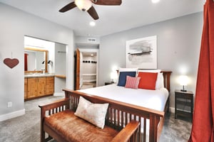 Guest bedroom with queen bed, wooden bedframe and leather and wooden bedroom  bench