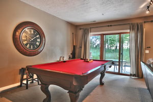 Enjoy a game of billiards in the den with striking red felt and wooden table, sliding glass door to private patio