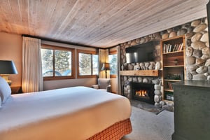 Main bedroom features a woodburning fireplace with rock surround