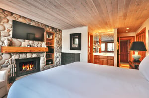 Main bedroom includes a comfortable kingsized bed with white linen