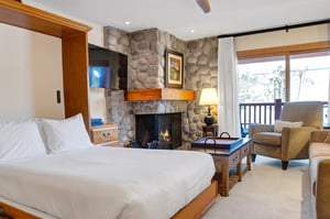 The living room includes a comfortable queen murphy bed with white linen