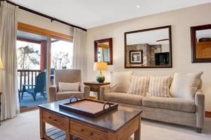 Living room has comfortable seating on the light fabric couch and chair
