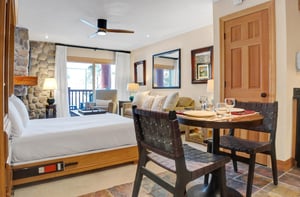 The living room includes a comfortable queen murphy bed with white linen