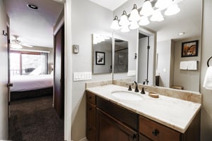 Ensuite main bathroom has white granite countertops, Alderwood cabinets and large mirror with a vanity light