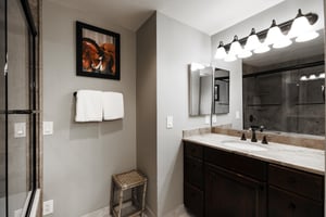 Ensuite main bathroom includes another vanity  white granite countertops, Alderwood cabinets and large mirror with a vanity light