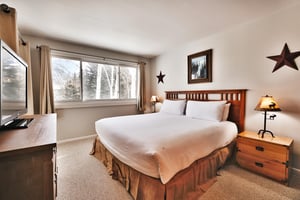 Main bedroom features a luxurious kingsized bed and an abundance of light