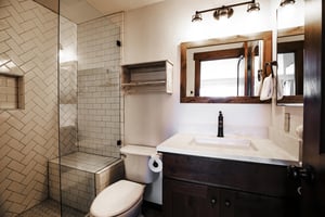 Ensuite main bathroom features a beautiful vanity with a quartzite countertop and beautiful framed mirror