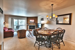 The dining room includes a wooden oval table and chairs with seating for 6