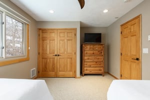Guest bedroom with wooden dresser and spacious closet