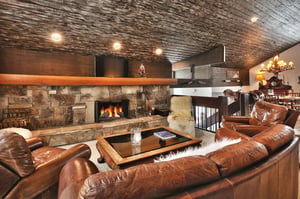 Enjoy the living area with leather couch and armchair, wooden coffee table and cozy wood burning fireplace