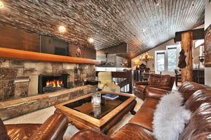Striking wooden mantle over the wood burning fireplace in the flagstone hearth in the living room