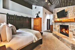Cozy gas fireplace and mantle mounted TV in the main bedroom