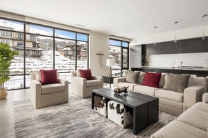 Expansive living room opens to the kitchen, stunning window walls, white upholstered sofas and two accent chairs