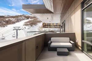 Main bedroom suite private patio with outdoor couch and views of the Sunrise ski lift and ski hill